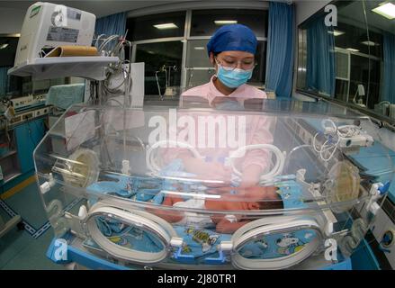 TAIZHOU, CHINE - 12 MAI 2022 - Une infirmière prend soin d'un nouveau-né à l'unité néonatale de soins intensifs (USIN) de l'hôpital populaire de Taizhou à Taizhou, EA Banque D'Images