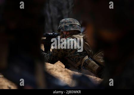 A Marine avec un deuxième peloton, Bravo Company, Marine Barracks Washington (MBW), tire un fusil M16A4 lors d'un entraînement d'infanterie à la base du corps des Marines Quantico, en Virginie, le 13 avril 2022. Marines et MBW ont effectué un insert aérien dans MV-22 Ospreys, des patrouilles à pied et une formation de feu vivant pour perfectionner les compétences en infanterie. (É.-U. Photo du corps marin par lance Cpl. Pranav Ramakrishna) Banque D'Images