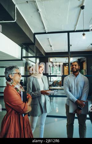 Des entrepreneurs joyeux souriant lors d'une réunion d'affaires dans un bureau moderne. Groupe de professionnels d'affaires réussis travaillant en équipe dans un Banque D'Images