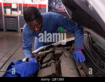 Homme professionnel mécanique de voiture de réparation de voiture dans la réparation automatique Banque D'Images