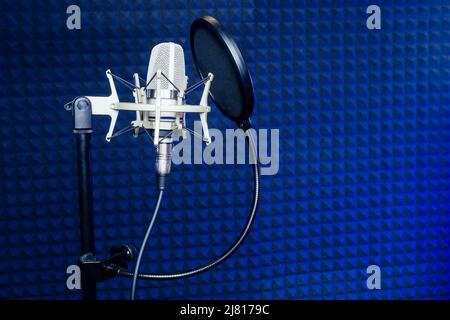 Microphone et casque dans un mur insonorisé de studio d'enregistrement. Banque D'Images