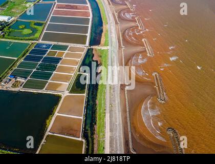 Photo aérienne de fermes de crevettes à proximité de la digue de mer dans les zones côtières de Giao Thuy Dist. Namdinh, Vietnam. Banque D'Images