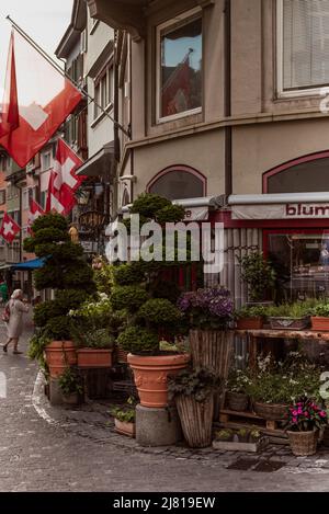 Zurich Suisse. 7 juillet 2018 Boutique de fleurs dans la vieille rue de Zurich. Rue décorée de drapeaux. Banque D'Images