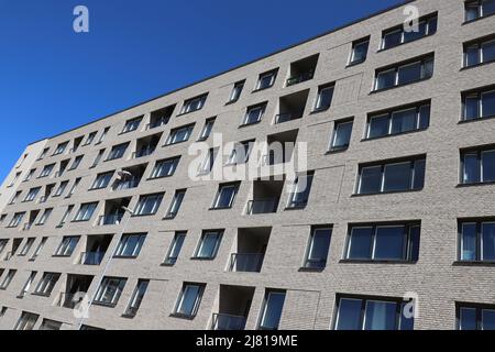 Vue à angle bas d'un appartement résidentiel moderne de plusieurs étages construit contre un ciel bleu clair. Banque D'Images