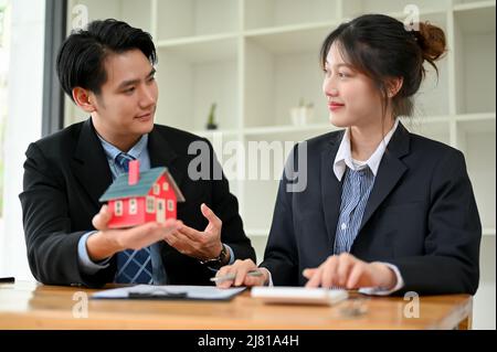 Agent immobilier masculin asiatique professionnel ayant une réunion avec une cliente féminine au bureau. Concept d'investissement immobilier Banque D'Images