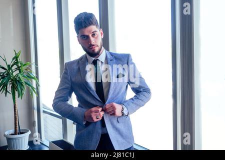 Homme d'affaires arabe dans les fenêtres en verre de l'aéroport de Dubaï Banque D'Images