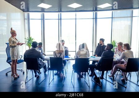 un groupe de succès afro-américains, européens, arabe et coréen homme d'affaires et femme d'affaires travaillant dans le bureau avec de grandes fenêtres en verre Banque D'Images