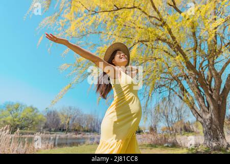 Femme enceinte bonne danse insouciante au printemps nature à bras ouverts. Asie fille bonheur gratuit sain été grossesse en plein air Banque D'Images