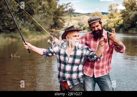 Pêcheurs hommes amis et truite trophée. Père et fils de pêche. Générations hommes pêche dans la rivière. Banque D'Images