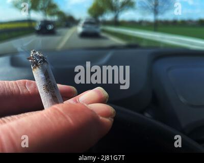 Berlin, Allemagne. 27th avril 2022. Une personne fume une cigarette en conduisant. Credit: Paul Zinken/dpa/Alay Live News Banque D'Images
