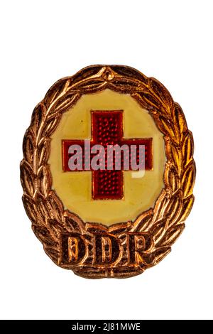 Potsdam, Allemagne - 06 MAI 2022. Médailles, ordres et médailles de la RDA (DDR). Gros plan d'un insigne de la Défense nationale de la Croix-Rouge allemande en bronze. CLI Banque D'Images