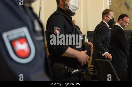 12 mai 2022, Basse-Saxe, Osnabrück: Le défendeur Hendrik Holt (2nd de droite) se trouve à côté de son avocat de défense Maximilian Pancic (à droite) dans la salle d'audience. Le verdict du procès sur les accusations de fraude à l'énergie éolienne doit être annoncé. Avec l'aide de projets d'énergie éolienne fictifs, l'ancien entrepreneur de la région d'Emsland aurait fraudé des compagnies d'énergie de plusieurs pays d'environ dix millions d'euros. Outre lui, quatre autres accusés, dont des membres de la famille, ont dû être jugés devant le tribunal régional d'Osnabrück. L'accusation est de frau gang et commercial Banque D'Images