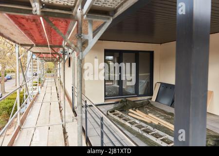 Échafaudage sur le chantier de construction d'une maison avec terrasse pour plâtrage extérieur et travaux de spatule Banque D'Images