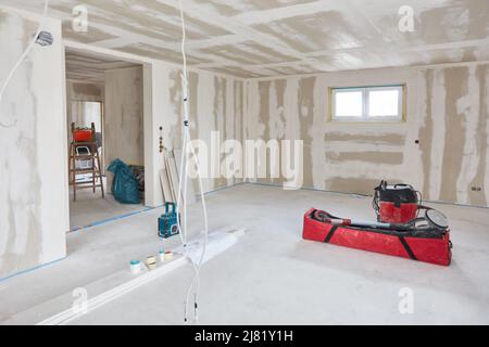 Finition intérieure après travaux de remplissage sur les murs et les plafonds dans un grand salon pendant la construction de la maison Banque D'Images