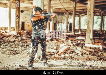 Airsoft sgrungeier dans le bâtiment de l'industrie du grunge. Banque D'Images