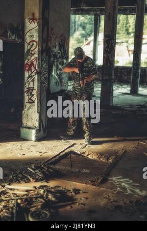 Airsoft sgrungeier dans le bâtiment de l'industrie du grunge. Banque D'Images