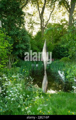 Une piscine centrale et la sculpture entouré de fleurs sauvages dans la Savills et David Harber Jardin à la RHS Chelsea Flower Show 2019, Londres, Royaume-Uni Banque D'Images