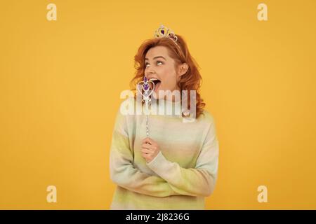 surprise. marraine fée. heureuse femme à tête rouge dans la couronne. reine avec baguette magique. Banque D'Images