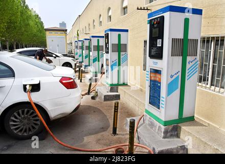 Qingdao, province chinoise de Shandong. 11th mai 2022. Un poste de charge partagé de véhicules électriques est vu près d'un parking d'autobus à Qingdao, dans la province de Shandong en Chine orientale, le 11 mai 2022. La ville de Qingdao a récemment ouvert des stations de recharge de bus électriques au public. Les véhicules privés et les voitures qui roulent peuvent partager les installations de recharge avec les bus publics. Credit: Li Ziheng/Xinhua/Alay Live News Banque D'Images