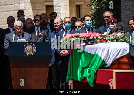 Ramlaah, Territoires palestiniens. 12th mai 2022. Le président palestinien Mahmoud Abbas prononce un discours d'adieu derrière le cercueil enveloppé de drapeau du journaliste d'Al Jazeera, Shireen Abu Akleh, lors d'un enterrement d'État à la résidence du président à Ramallah. Abu Akleh, 51 ans, figure éminente du service de presse arabe de la chaîne Al-Jazeera, a été tué par balle le 11 mai lors d'une confrontation entre les soldats israéliens et les Palestiniens dans la ville de Djénine, en Cisjordanie. Crédit : Ilia Yefimovich/dpa/Alay Live News Banque D'Images