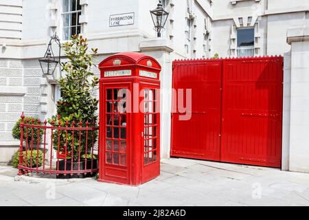 Coffret téléphonique britannique traditionnel rouge K2, conçu par Sir Giles Gilbert Scott, à côté d'une porte rouge sur Farringdon Road, Clerkenwell, Londres, Royaume-Uni Banque D'Images