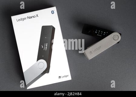 Russie, Krasnodar - 15 avril 2022: Portefeuille matériel crypto Ledger Nano X avec boîte sur fond gris Banque D'Images