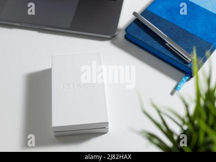 Russie, Krasnodar - 15 avril 2022 : boîte blanche avec porte-monnaie Ledger pour la crypto-monnaie sur le bureau. Solution de stockage sécurisée pour bitcoin. Banque D'Images