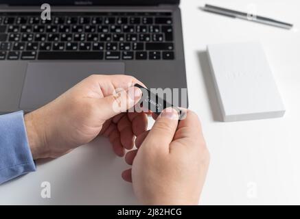 Russie, Krasnodar - 15 avril 2022: Man Holding Hardware crypto-monnaie Ledger. Stockage pour Bitcoin, Ethereum et autres pièces de monnaie et jetons Banque D'Images