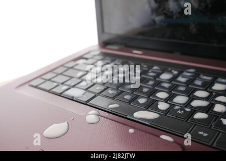 le café déborde sur le clavier de l'ordinateur portable. gros plan Banque D'Images