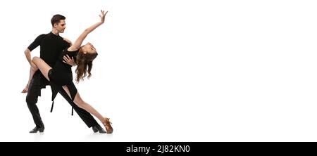 Circulaire. Portrait dynamique de jeunes danseurs émotifs vêtus de tenues noires dansant danse de salle de bal isolée sur fond blanc. Concept d'art, beauté, musique Banque D'Images