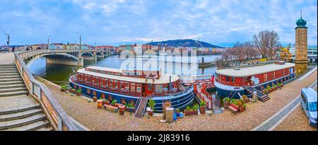 Vue panoramique sur la rivière Vltava, son remblai, le pont de Jirasek, la tour d'eau de Sitkov, les hôtels et restaurants de bateaux, le quartier de Smichov et la colline de Petrin sur t Banque D'Images