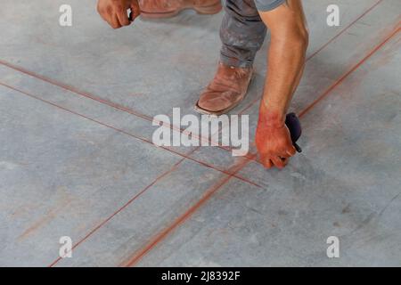 le travailleur de la construction présente les plans sur le sol pour l'installation de charpentes métalliques Banque D'Images