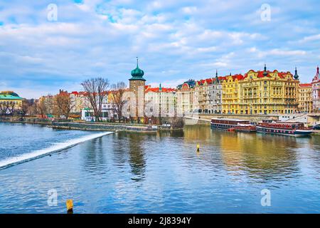 La tour d'eau en pierre de Sitkov en face de bâtiments colorés de l'Embankment de Masaryk avec la rivière Vltava en premier plan, Prague, République tchèque Banque D'Images