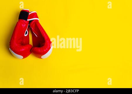 Gants rouges espace jaune boxer lue isolé fonte, concept sain équipement de style de vie poids pour le sport de poing sportif, deux forces. Formation Banque D'Images