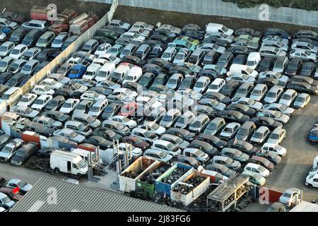 Vue aérienne du grand parking de junkyard avec des rangées de voitures brisées jetées. Recyclage des vieux véhicules Banque D'Images