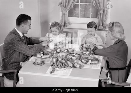 1950S FAMILLE DE QUATRE PERSONNES AYANT DÎNÉ À LA TABLE DE SALLE À MANGER MÈRE PÈRE GARÇON FILLE PARENTS COUPANT DE LA NOURRITURE POUR LES ENFANTS - D2769 HAR001 VÊTEMENTS HARS À L'INTÉRIEUR LÉGUMES NOSTALGIQUE PAIRE 4 MÈRES VIEUX TEMPS NOSTALGIE FRÈRE VIEILLE MODE SOEUR 1 JEUNE STYLE COMMUNICATION JEUNES ADULTES TRAVAIL D'ÉQUIPE FILS FAMILLES JOIE STYLE DE VIE FEMMES MARIÉS FRÈRES STUDIO SHOT CONJOINT ÉPOUX SANTÉ MAISON VIE COPIE ESPACE DEMI-LONGUEUR FEMMES FILLES PERSONNES SOINS MÂLES VIANDE FRÈRES ET SŒURS PÈRES B&W PARTENAIRE COMBINAISON ET CRAVATE ROULEAUX BONHEUR GRAND ANGLE DADS NUTRITION LA CONNEXION DE LA PERSONNE QUI S'EN CHARGE CONSOMME LA NOURRITURE ÉLÉGANTE Banque D'Images