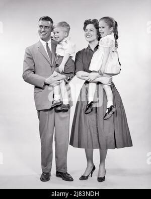 1950S PORTRAIT DE LA FAMILLE DE 4 MÈRE ET PÈRE DEBOUT CHACUN TENANT UN ENFANT FEMME TENANT UNE FILLE ET HOMME TIENT FILS - J8048 HAR001 HARS PAIRE NOSTALGIQUE 4 MÈRES TEMPS VIEUX NOSTALGIE FRÈRE MODE VIEILLE SOEUR JUVÉNILE STYLE JEUNE ADULTE TRAVAIL D'ÉQUIPE FILS HEUREUX FAMILLES JOIE STYLE DE VIE SATISFACTION FEMMES FRÈRES MARIÉS STUDIO SHOT CONJOINT ÉPOUX SAINTETÉ VIE VIE COPIE ESPACE AMITIÉ FEMME PLEINE LONGUEUR FILLES PERSONNES S'OCCUPANT HOMMES FRÈRES ET SŒURS PÈRES B&W PARTENAIRE COMBINAISON ET CRAVATE BONHEUR GAI ET DADS FIERTÉ SOEUR SOURIRES JOYEUX STYLE SOUTIEN BÉBÉ GARÇON COOPÉRATION CROISSANCE TIENT Banque D'Images