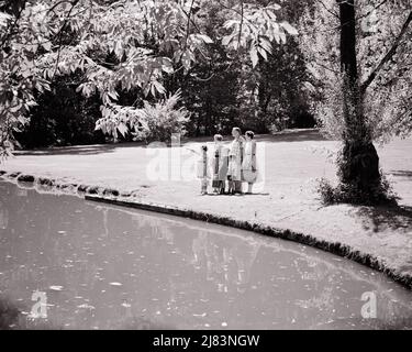 1950S FAMILLE DE 6 DEBOUT PRÈS DE L'ÉTANG DANS LE PARC PORTANT DES PANIERS DE PIQUE-NIQUE THERMOS MÈRE PÈRE 4 ENFANTS UNE FILLE POINTANT À VOIR - J8077 HAR001 HARS EXTÉRIEUR PORTE MARI DAD ARBRES REPAS MOM VÊTEMENTS NOSTALGIQUE ACTIVE PAIRE 4 FEUILLES SUBURBAIN MÈRES VIEUX TEMPS NOSTALGIE FRÈRE VIEILLE MODE SOEUR 1 STYLE JUVÉNILE POND FILS FAMILLES JOIE STYLE DE VIE SATISFACTION FEMMES FRÈRES MARIÉS CONJOINT ÉPOUX SAINTETÉ VIE À LA MAISON 6 NATURE COPIE ESPACE AMITIÉ FEMMES FILLES PLEINE LONGUEUR PERSONNES PITTORESQUE INSPIRATION HOMMES FRÈRES ET SŒURS PÈRES B&W PARTENAIRE ÉTÉ ACTIVITÉ BONHEUR AVENTURE LOISIR Banque D'Images