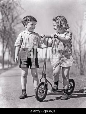 1930S 2 ENFANTS PARLANT SUR LE TROTTOIR FILLE DEBOUT AVEC LES MAINS SUR LE GUIDON DE SCOOTER GARÇON PORTANT DES SHORTS SOURIANT TENANT LA FILLE ARM - J8285 HAR001 HARS COPIE ESPACE AMITIÉ PERSONNES PLEINE LONGUEUR HOMMES TRANSPORT B&W ÉTÉ BONHEUR GAI AVENTURE RELATIONS SOURIRES CONNEXION JOYEUX STYLE SCOOTER CROISSANCE GUIDON SAISON TOGETHERNESS NOIR ET BLANC CAUCASIEN ETHNICITÉ HAR001 VIEUX MODE Banque D'Images