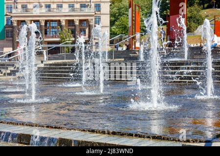 Jets denses d'eau s'échappant dans la fontaine de la ville lors d'une journée ensoleillée claire sur la place de la ville. Banque D'Images