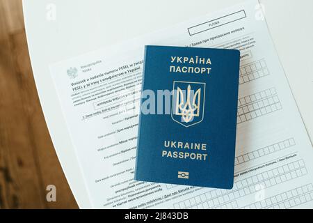 Document PESEL, passeport ukrainien et stylo sur fond de table blanc. Banque D'Images