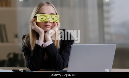 Fatigué endormi drôle paresseux caucasien d'affaires avec des notes collantes sur les yeux lunettes avec des autocollants. Les travailleuses fatiguées qui se présentent sur le lieu de travail s'assoient Banque D'Images