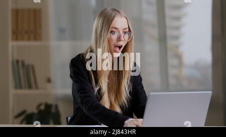 Succès caucasien millénaire entreprise femme fille dans des verres victoires dans les Paris en ligne reçoit la notification avec de bonnes nouvelles positives offre de résultats Banque D'Images