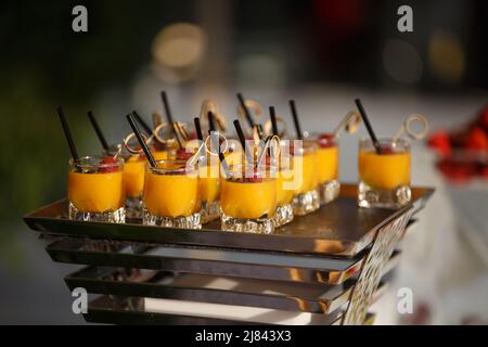 Desserts aux couleurs vives en tasses sur la table de mariage. Banque D'Images