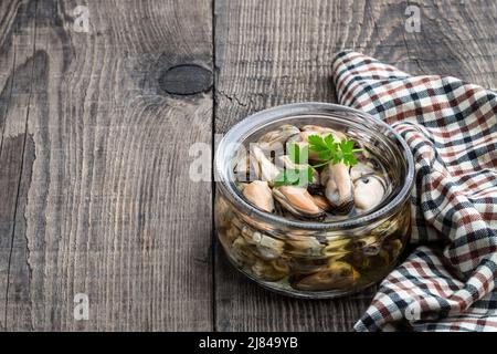 Moules marinées dans un pot en verre sur une table en bois Banque D'Images