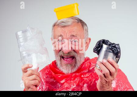 un vieil homme caucasien tient des déchets en plastique sur fond blanc de studio Banque D'Images