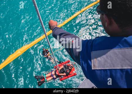 Porto Rico. 13th avril 2022. Boatswain Mate 1st classe Emmanuel Dixon, à droite, affecté au navire de combat littoral variante Freedom USS Billings (LCS 15), supervise une ligne de levage pendant la recherche et le sauvetage (SAR) et l'entraînement de l'homme à la mer pendant que le navire est à Ponce, Porto Rico, le 13 avril 2022. Billings est déployé dans la zone d'opérations de la flotte américaine 4th pour appuyer la mission de la Force opérationnelle interagences conjointe Sud, qui comprend des missions de lutte contre le trafic de drogues illicites dans les Caraïbes et le Pacifique oriental. Credit: U.S. Navy/ZUMA Press Wire Service/ZUMAPRESS.com/Alamy Live News Banque D'Images