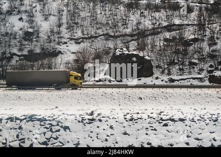 Vue latérale d'un camion sur la route enneigée. Banque D'Images