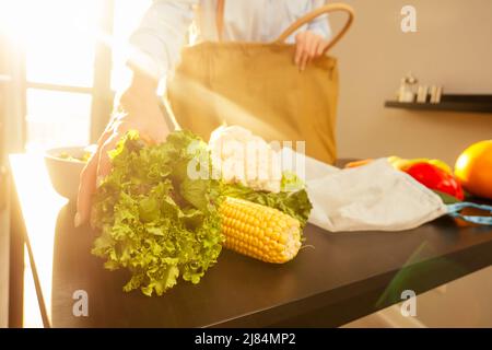 écologique redhaired ginger femme trier les achats de coton eco sac cuisine coucher de soleil lumière background.no plastique paquet vert paix Banque D'Images