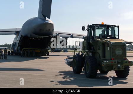 Un Airman du groupe d'intervention en cas d'urgence 156th conduit un chariot élévateur tout-terrain 10K pour livrer des rampes de chargement pour un C-5M Super Galaxy depuis l'aile 433rd du pont aérien de la réserve de la Force aérienne, lors d'une grève du Sud au Centre d'entraînement de préparation au combat de Gulfport, Gulfport, Mississippi, le 22 avril 2022. Southern Strike 2022 est un exercice de combat multinational conjoint à grande échelle organisé par la Garde nationale du Mississippi, qui fournit un entraînement tactique pour toute la gamme des conflits. (É.-U. Photo de la Garde nationale aérienne par le Sgt. Rafael Rosa) Banque D'Images